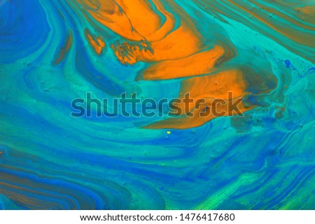 photography of abstract marbleized effect background. Blue, mint, orange and white creative colors. Beautiful paint