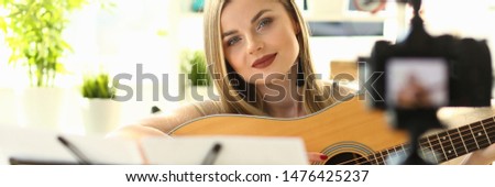 Social Media Learning Recording Musical Video. Young Woman Blogger Relaxing and Playing Guitar Filming Process on Camera at Home. Attractive Girl Broadcast Online Music Creating Tutorial
