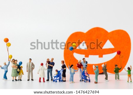 Miniature people:  Happy family holding balloon on white background Happy Halloween concept
