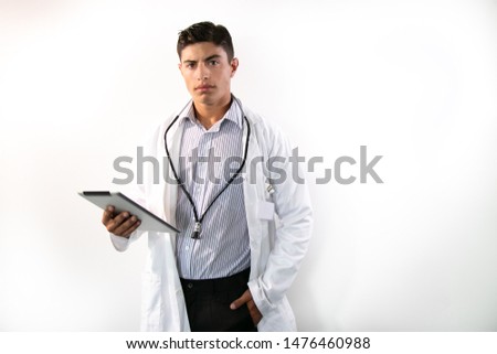 Handsome doctor with white lab coat, stethoscope and clipboard looking at camera on isolated background