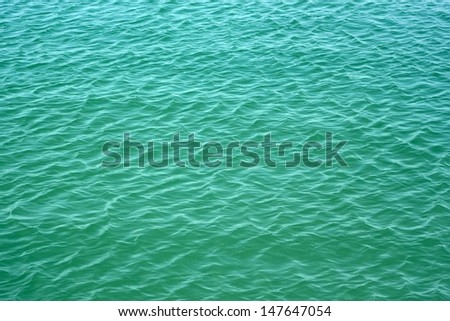 Easy waves on surface of turquoise color sea water in a calm summer weather