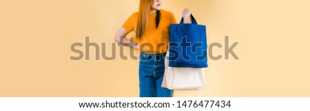 web banner save world and environment activity from beauty 30s to 40s asian woman shopping by use fabric bag instead of plastic bag with yellow pastel background