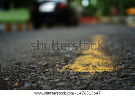 The paved road has yellow traffic lines on the surface. Blurred background