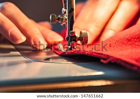 Tailoring Process - Women's hands behind her sewing Royalty-Free Stock Photo #147651662