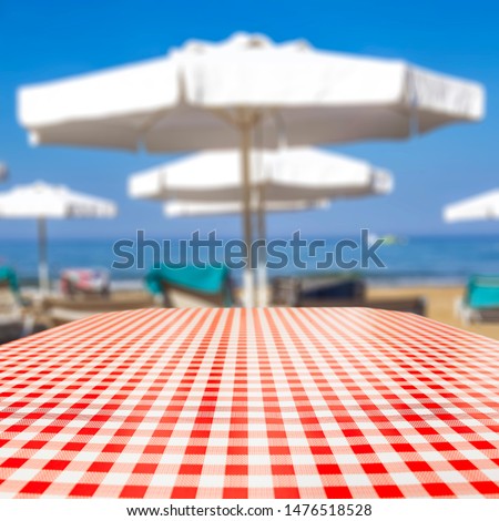 Table background and beach on sunny day in distance. Empty space for products and decoration.