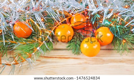 Fir branches, tangerines and new year decoration on wooden background with copy space. Flat lay and top view. Merry xmas and happy new year concept