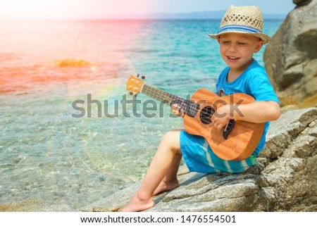 happy child playing guitar by the sea greece on nature background