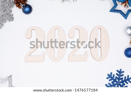 Christmas and New Year composition. 2020 simbols and fir branches with cones and christmas balls in silver and blue colours on white background. Flat lay, top view, copy space for text