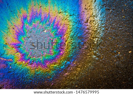 Colored oil stain on the asphalt. A rainbow slick of gasoline. Abstract background. Royalty-Free Stock Photo #1476579995