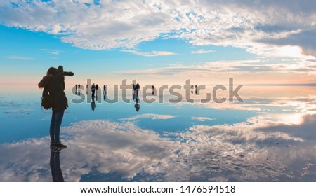 Silhouette of lone photographer takes a photo at amazing sunset reflected in waters of salt lake, Ankara