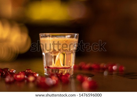baileys shot with grenadine seeds on wooden table