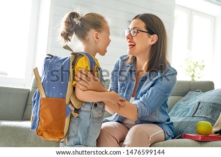 Parent and pupil of preschool. Woman and girl with backpack behind back. Beginning of lessons. First day of fall. Royalty-Free Stock Photo #1476599144