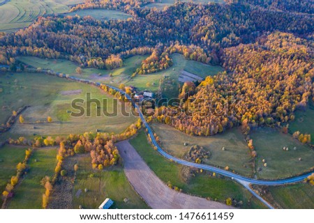 Aerial picture of a countryside village road. Drone shot of agricultural fields, forest. Transylvania, Romania