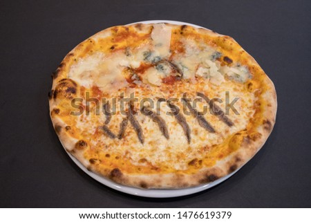 Several different pizzas on a black wooden restaurant table