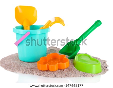 Children's toys on sand isolated on white