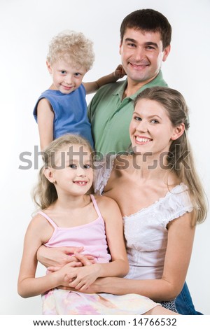 Portrait of father, mother and their daughter and son looking at camera happily