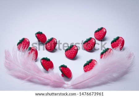 Conceptual strawberries with feather. flat lay romantic