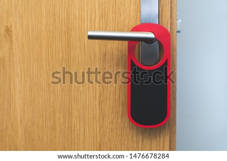 A red and black sign on a door handle