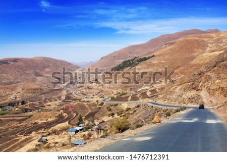 Beautiful highland valley landscape, scenery panoramic view, bright blue sunny sky background, road and village in Drakensberg mountains, Lesotho called Kingdom in the clouds, Southern Africa travel