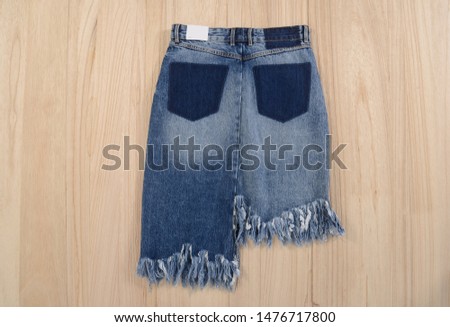 Back blue denim skirt jeans on wooden background


