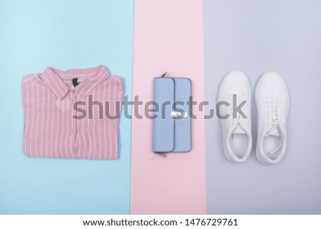 Fashion Woman Accessories Set ,folded striped shirt and white shoes and gray clutch on pink,gray, blue background


