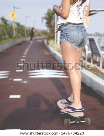 Girl riding on its longboard at the park
