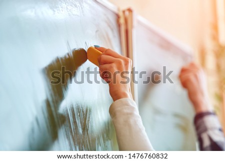Soft focus blue Chalkboard or green board. High School Student of Hand holding white chalk writing on green board in classroom .Education concept