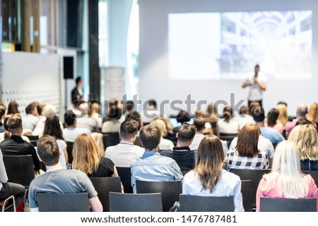 Audience at the conference hall. Male speaker giving a talk in conference hall at business event. Business and Entrepreneurship concept. Focus on unrecognizable people in audience. Royalty-Free Stock Photo #1476787481