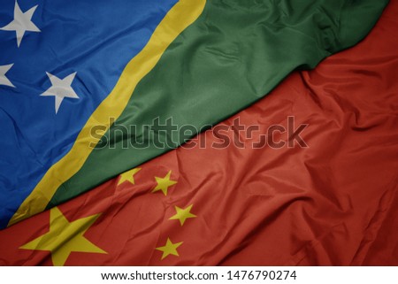 waving colorful flag of china and national flag of Solomon Islands. macro