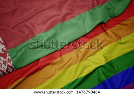 waving colorful gay rainbow flag and national flag of belarus. macro