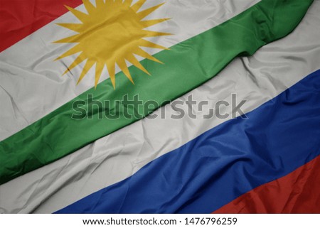 waving colorful flag of russia and national flag of kurdistan. macro