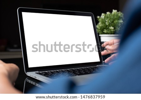 Mockup image of business man working on blank screen laptop, computer on table, typing on keyboard, networking in modern office for website or application design, close up, over shoulder view