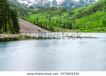 Maroon Bells lake water at sunrise in Aspen, Colorado during blue hour dawn with closeup of reflection June 2019 summer