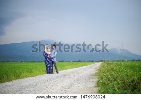 Landscape view of a Muslim Asian couple husband and wife posing happily at paddy field Gunung Jerai, Kedah.
