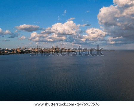 Aerial panoramic view of Toronto City skyline with Lake Ontario and blue sky with white clouds.