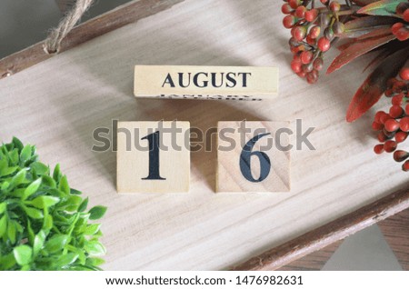 August 16. Date of August month. Number Cube with a flower and Sign wood on Diamond wood table for the background.