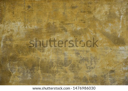 Painted plaster background with distressed yellow and brown color.