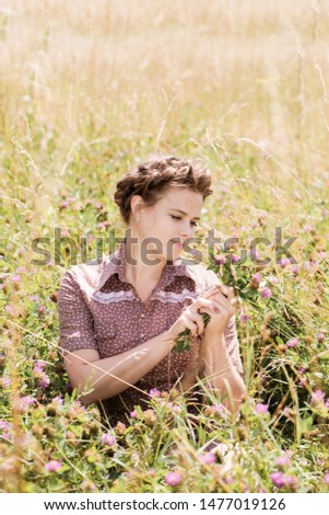 The girl in the field collects a bouquet of clover