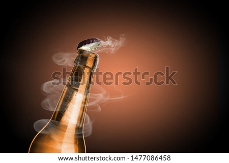 Cold wet bottle of chilled drink with drops close up. Opening of beer cap with the gas output.