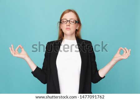 Keep calm concept. Woman in glasses in a zen pose.