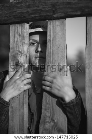 woman looking through a fence