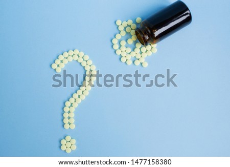 Assorted pharmaceutical medicine pills, tablets and capsules and bottle on blue background. Drugs and various narcotic substances. Copy space for text. Stock photo for design. 