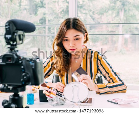 Pretty asian woman blogger during streeming the cosmetic online review by internet at home office