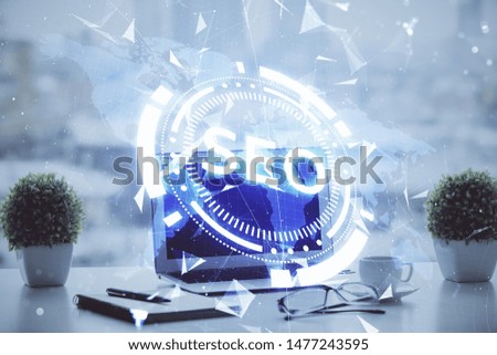 Double exposure of table with computer and seo drawing hologram. Search optimization concept.