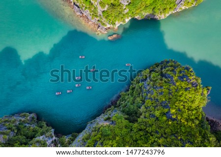 Aerial view of tourists on the boat in Vung Vieng floating fishing village and rock island, Halong Bay, Vietnam, Southeast Asia. UNESCO World Heritage Site. Junk boat cruise to Ha Long Bay.