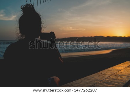 girl taking a photo with her cellphone at venao beach