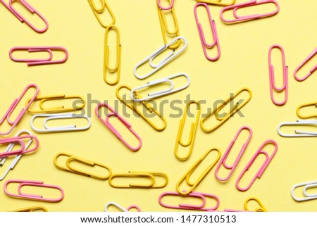 Multi-colored paper clips on a colored background.
