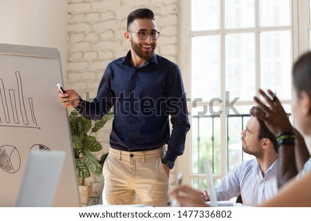 Happy businessman coach speaker and diverse team people discuss business presentation at corporate training, smiling male manager presenter work with flip chart talk to audience at lecture workshop Royalty-Free Stock Photo #1477336802