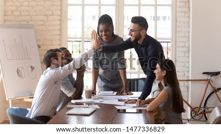 Happy motivated male colleagues executives team give high five at multiracial group meeting celebrating shared win, good teamwork result, corporate success victory thanking for help support in work Royalty-Free Stock Photo #1477336829