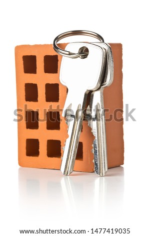 House keys on bricks over white background with selective focus - home owner, real estate or house building concept